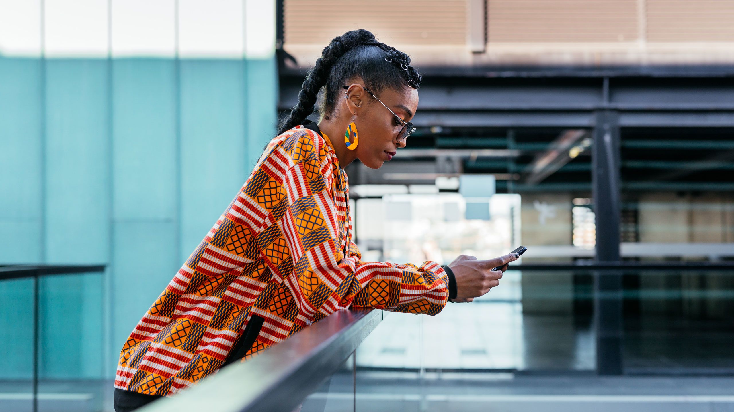 Trendy woman using smartphone on terrace